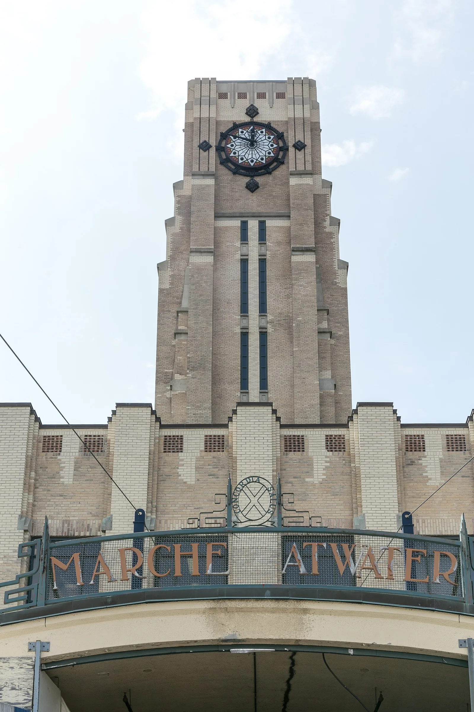 The art deco clock tower and entrance of the Atwater Market in Montreal under a winter sky