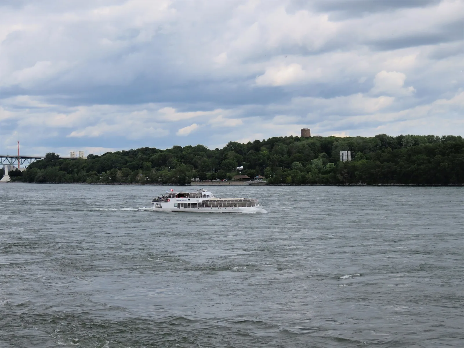 A glass-roofed Bateau-Mouche cruise boat on the St Lawrence River off Île Sainte-Hélène