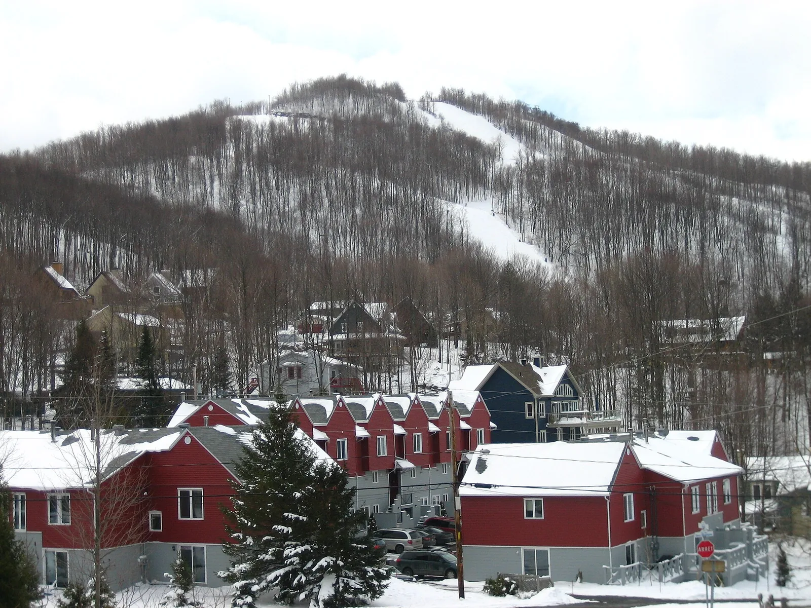 Snowy ski runs at Bromont above red and grey chalets in the Eastern Townships, near the Balnea Nordic spa