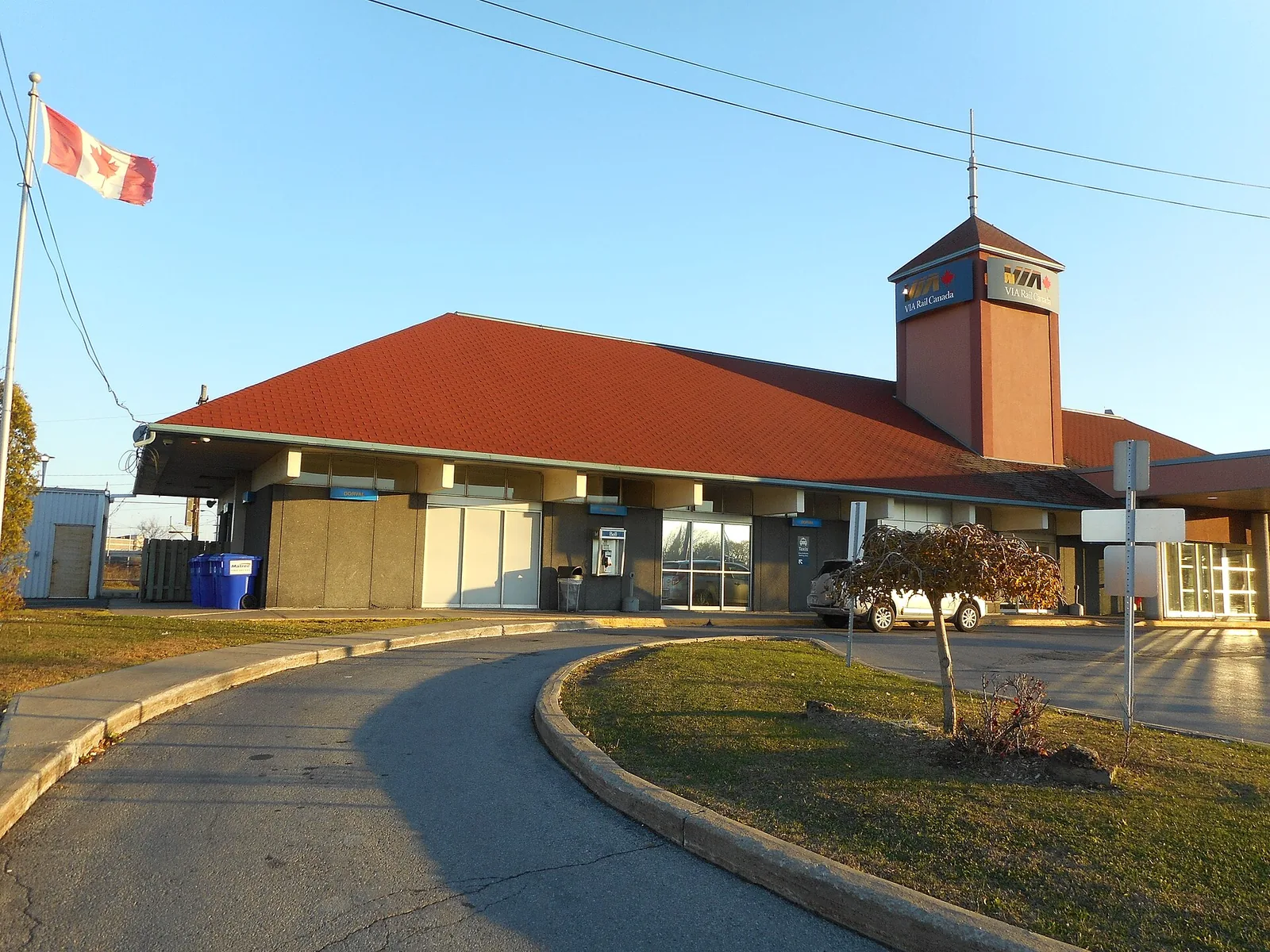 Dorval VIA Rail station building with a red roof and clock tower, near Montreal airport