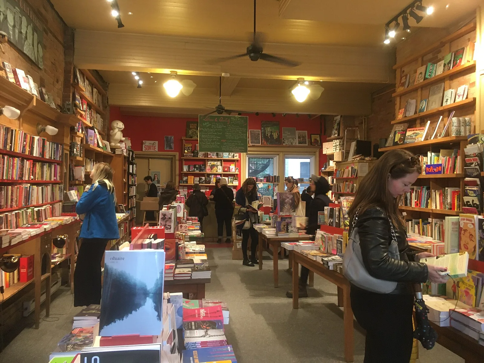 Shoppers browsing tables and shelves of books inside Librairie Drawn and Quarterly in Mile End