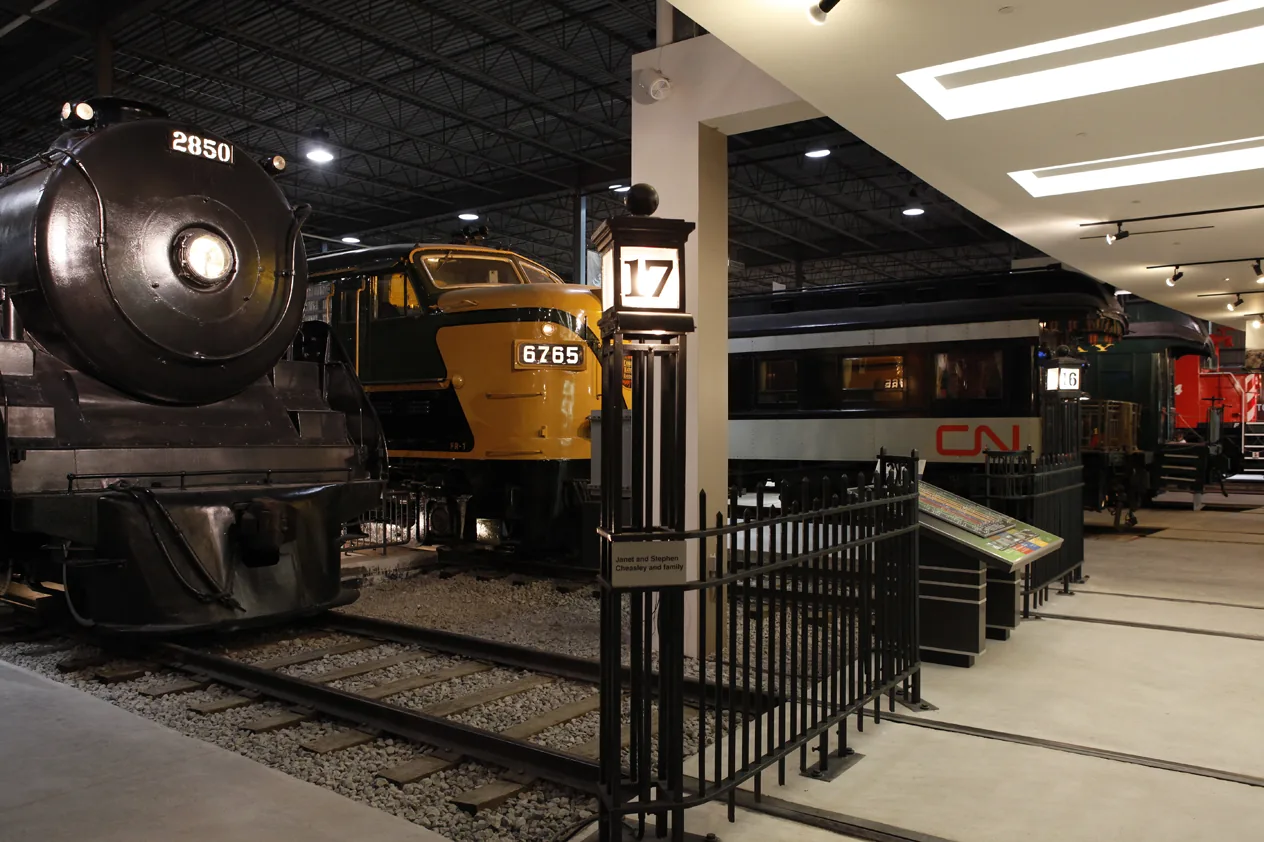 Historic steam and diesel locomotives lined up inside the main hall at Exporail railway museum