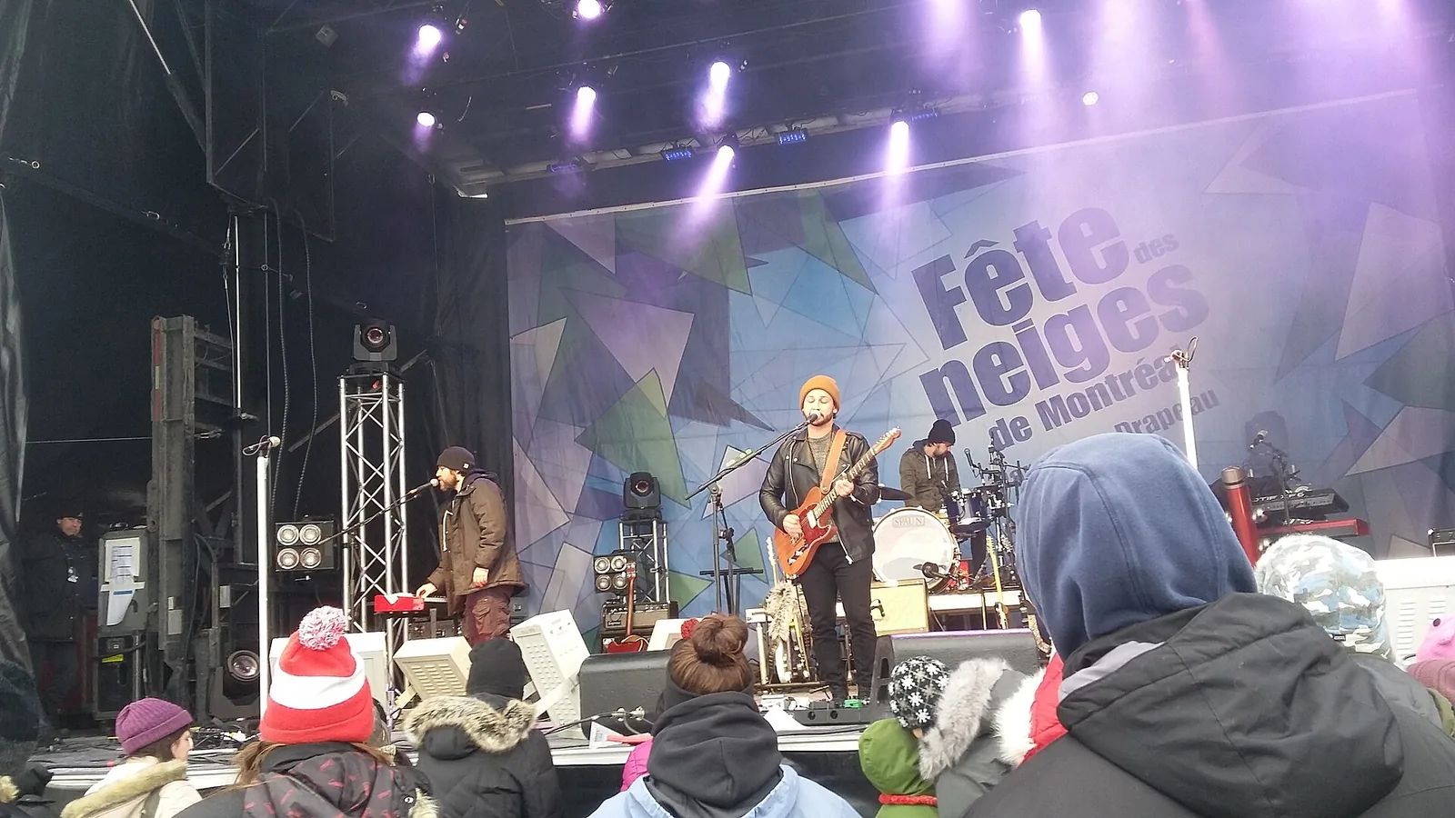 Bundled-up crowd watching a band on the outdoor stage at the Fête des neiges de Montréal