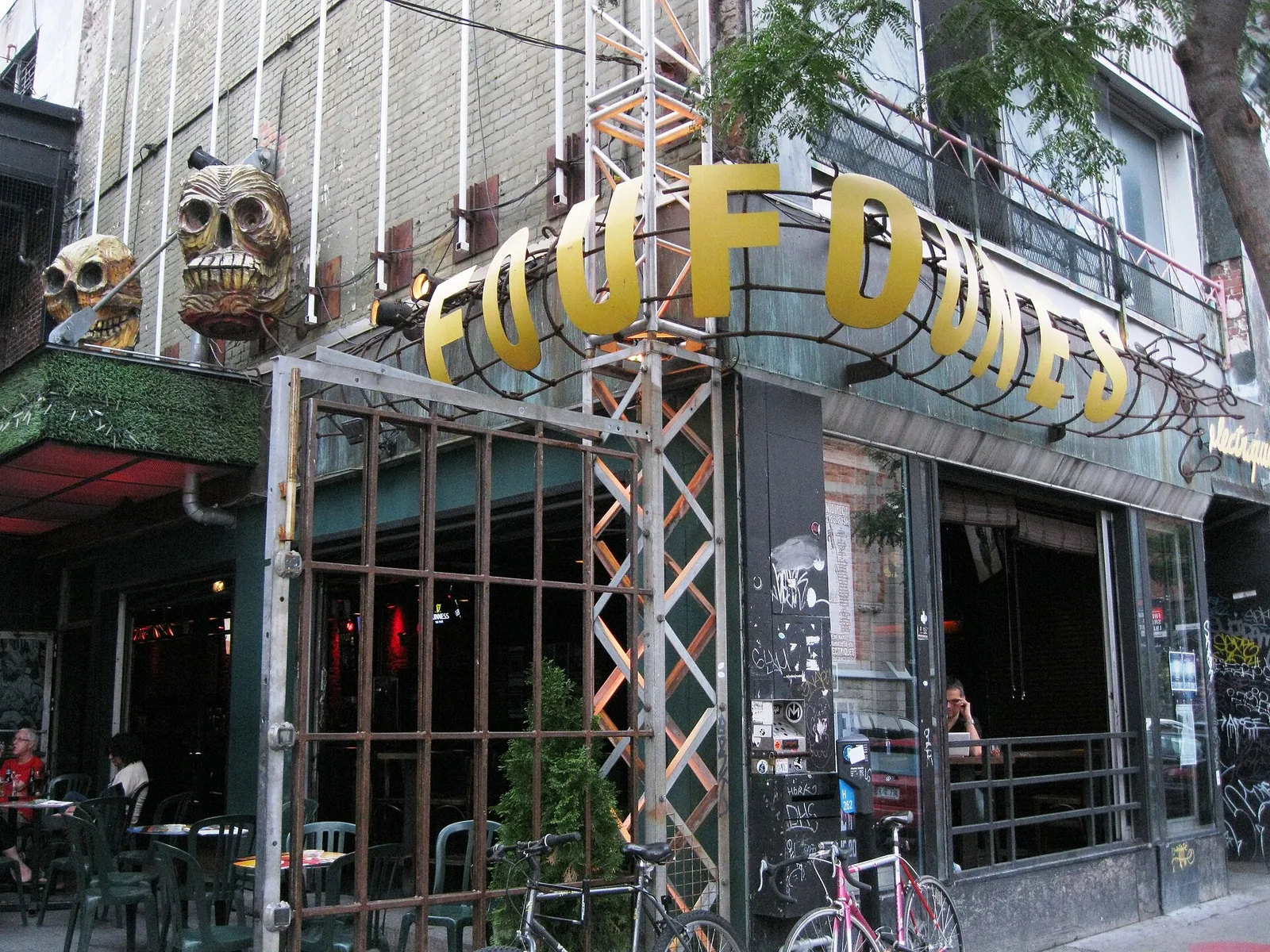 The skull-decorated facade and terrace of Foufounes Électriques bar on rue Sainte-Catherine Est