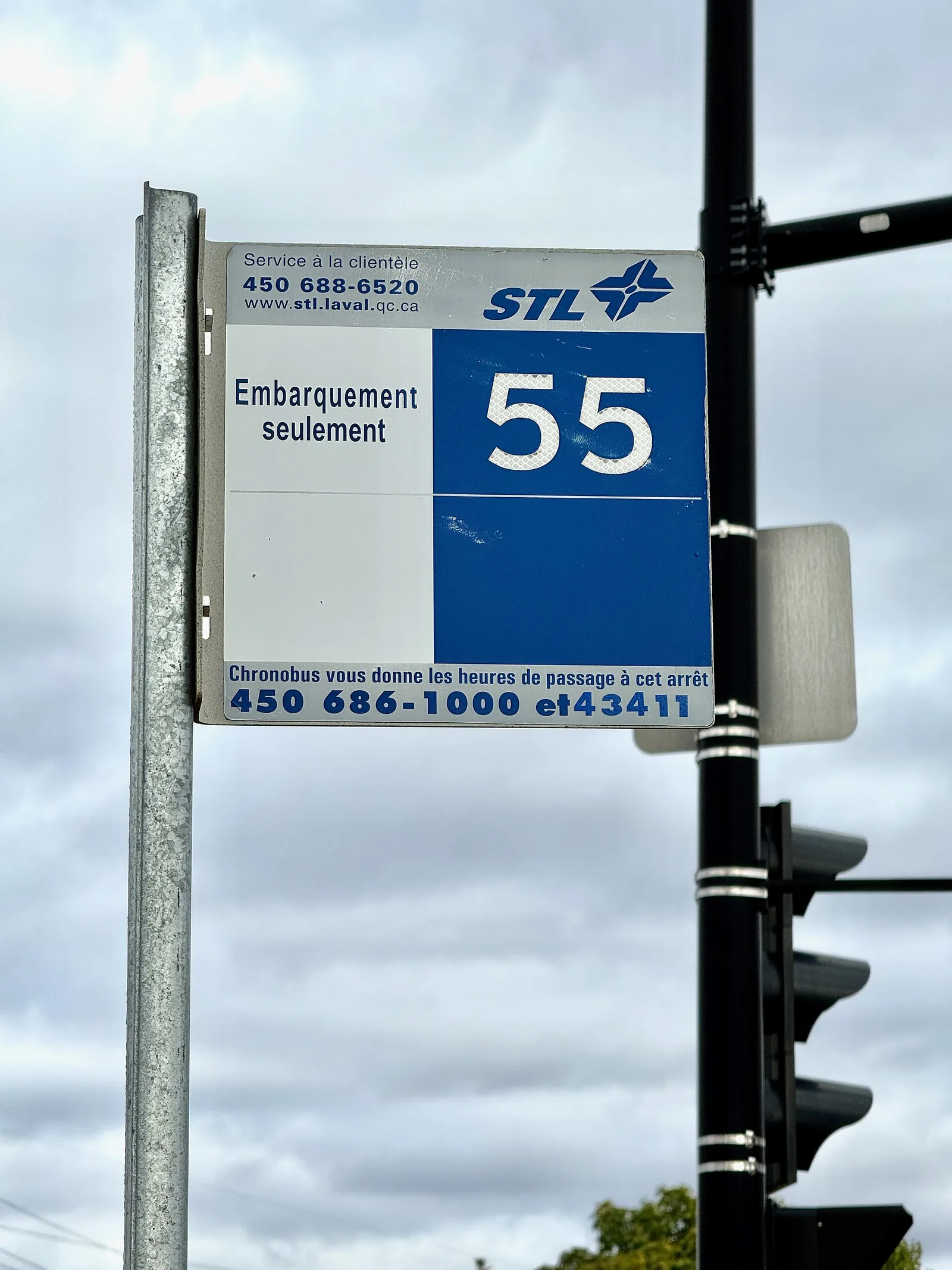 A French-only bus stop sign reading Embarquement seulement, showing the French signage visitors see around Montreal