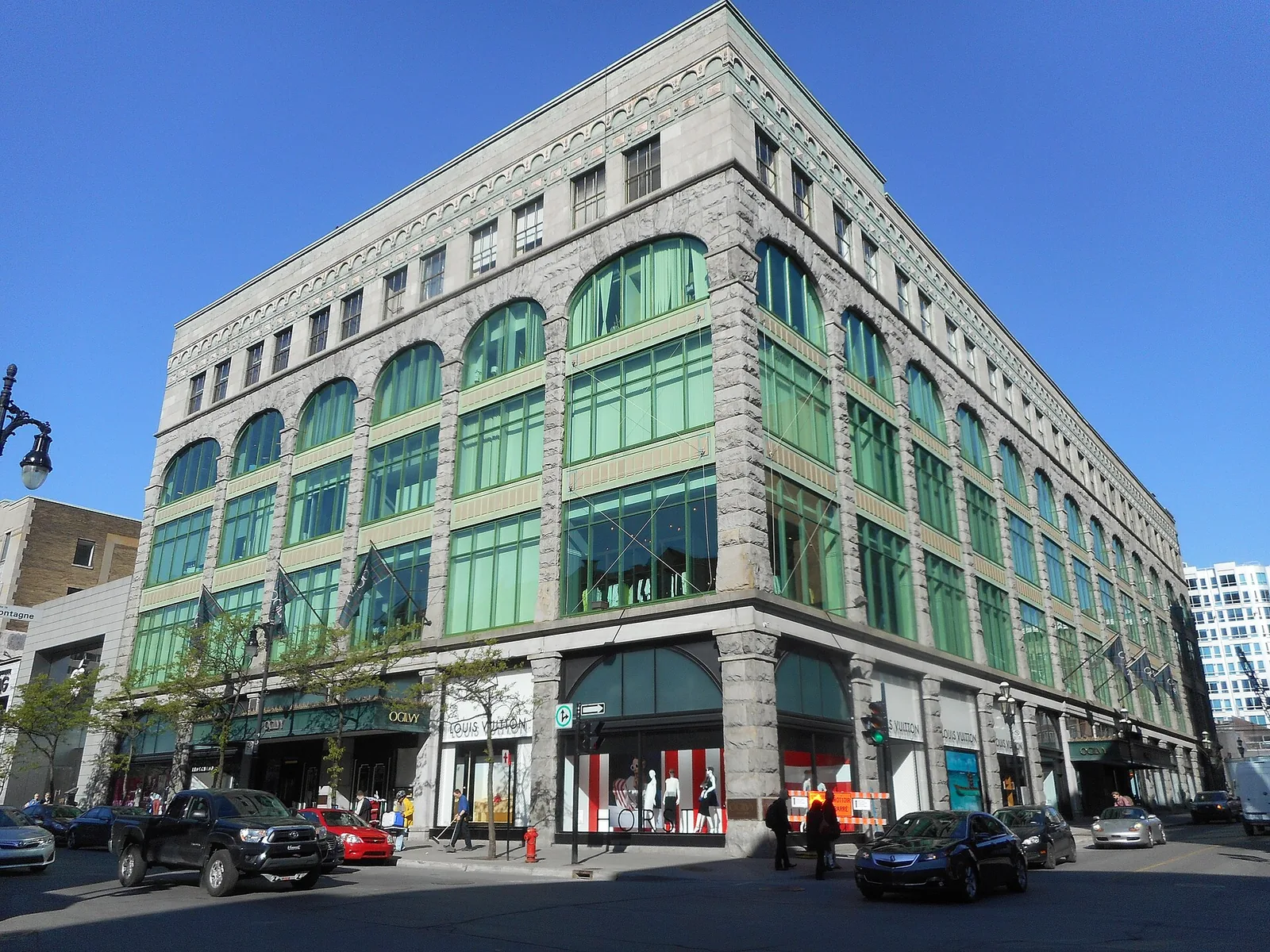 The arched green windows and stone facade of the Holt Renfrew Ogilvy department store on rue Sainte-Catherine