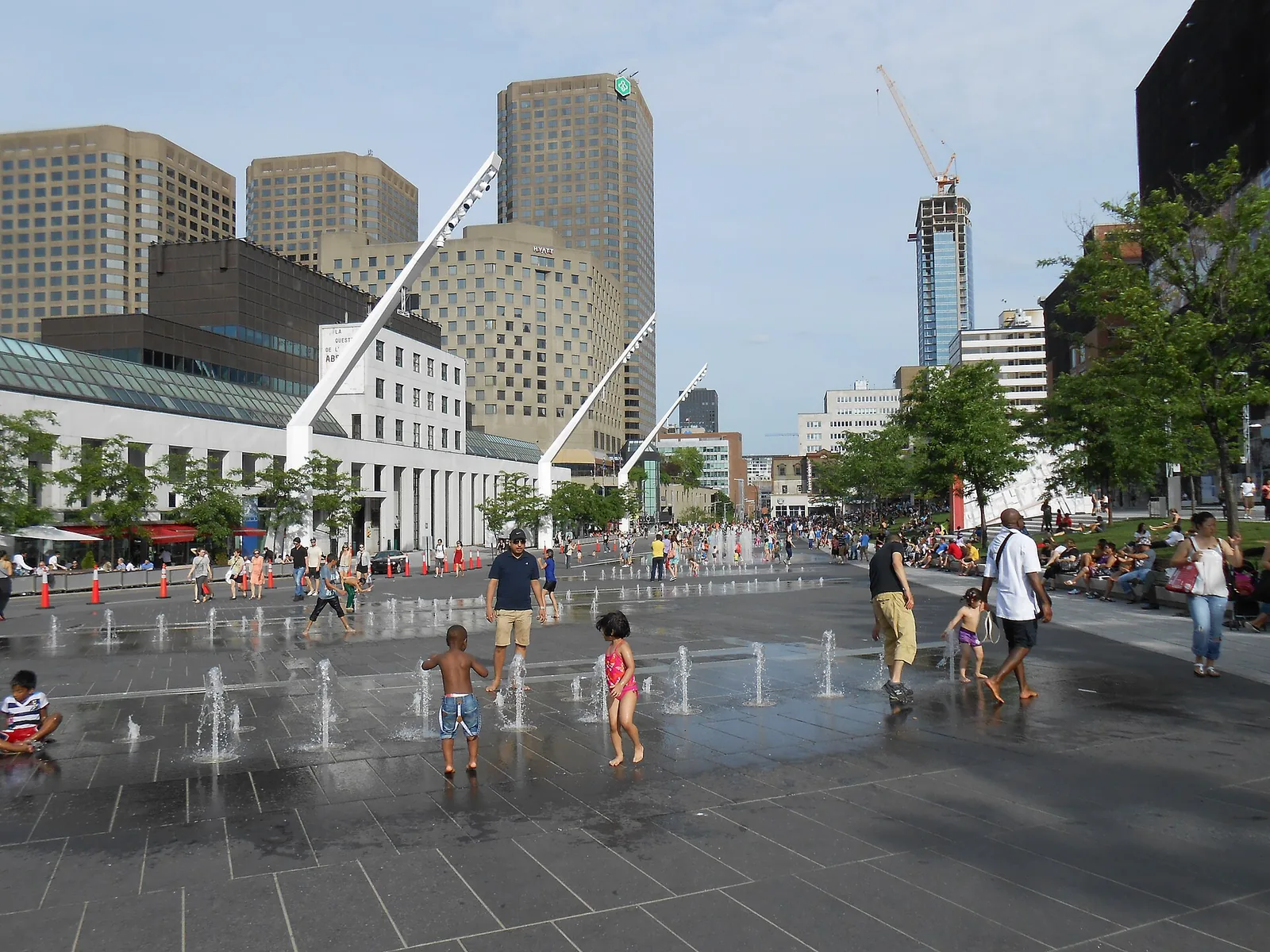 Children playing in the fountains on the Place des Festivals in Montreal on a hot summer day