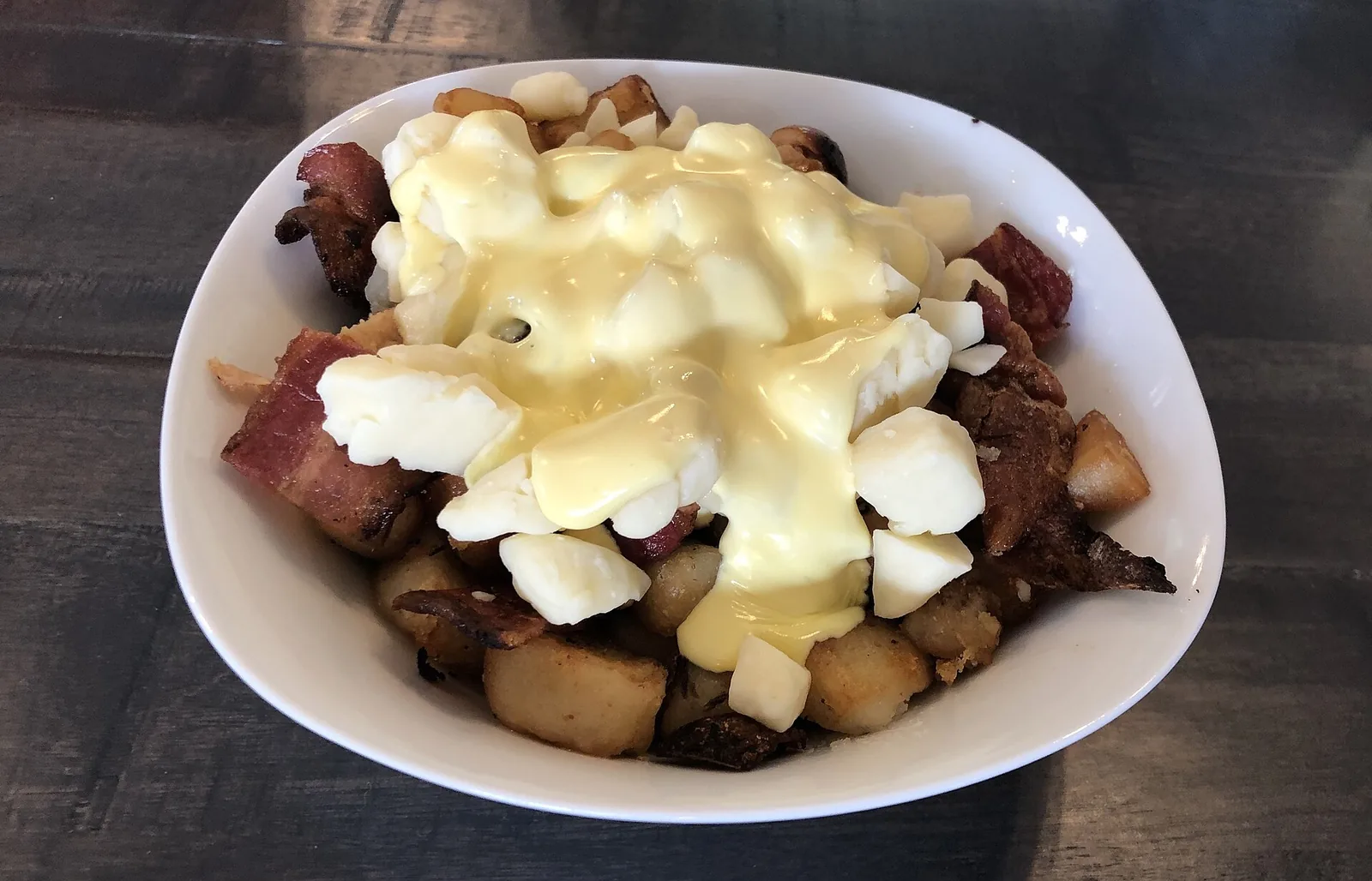 A bowl of poutine topped with cheese curds and gravy, Quebec's signature dish