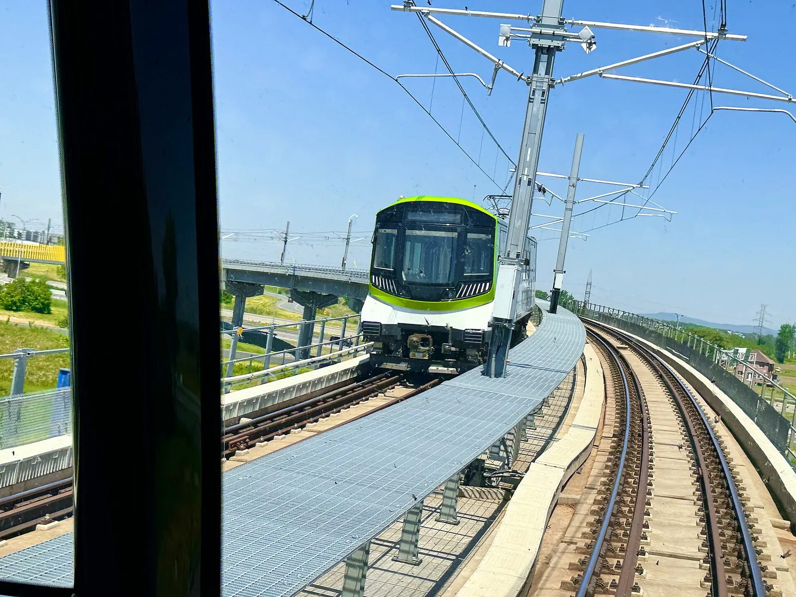 A REM light metro train on an elevated viaduct in the Montreal area