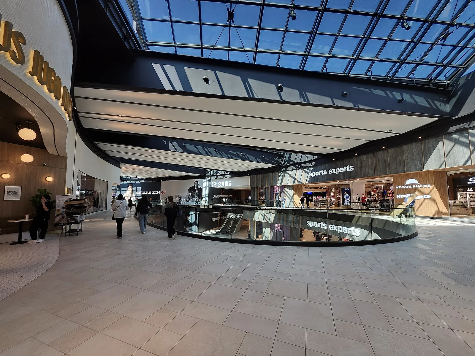 Glass-roofed gallery of shops inside the Royalmount shopping centre in Montreal
