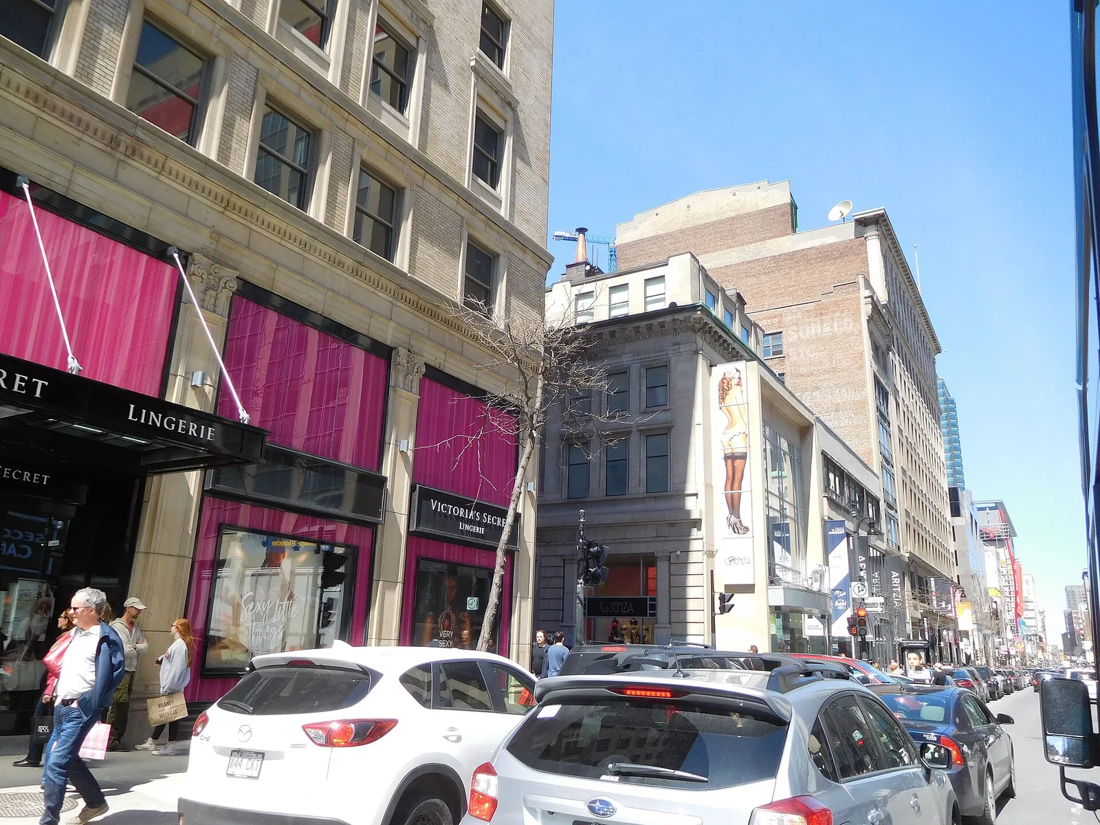 Shop fronts and traffic on rue Sainte-Catherine Ouest at rue Stanley in downtown Montreal