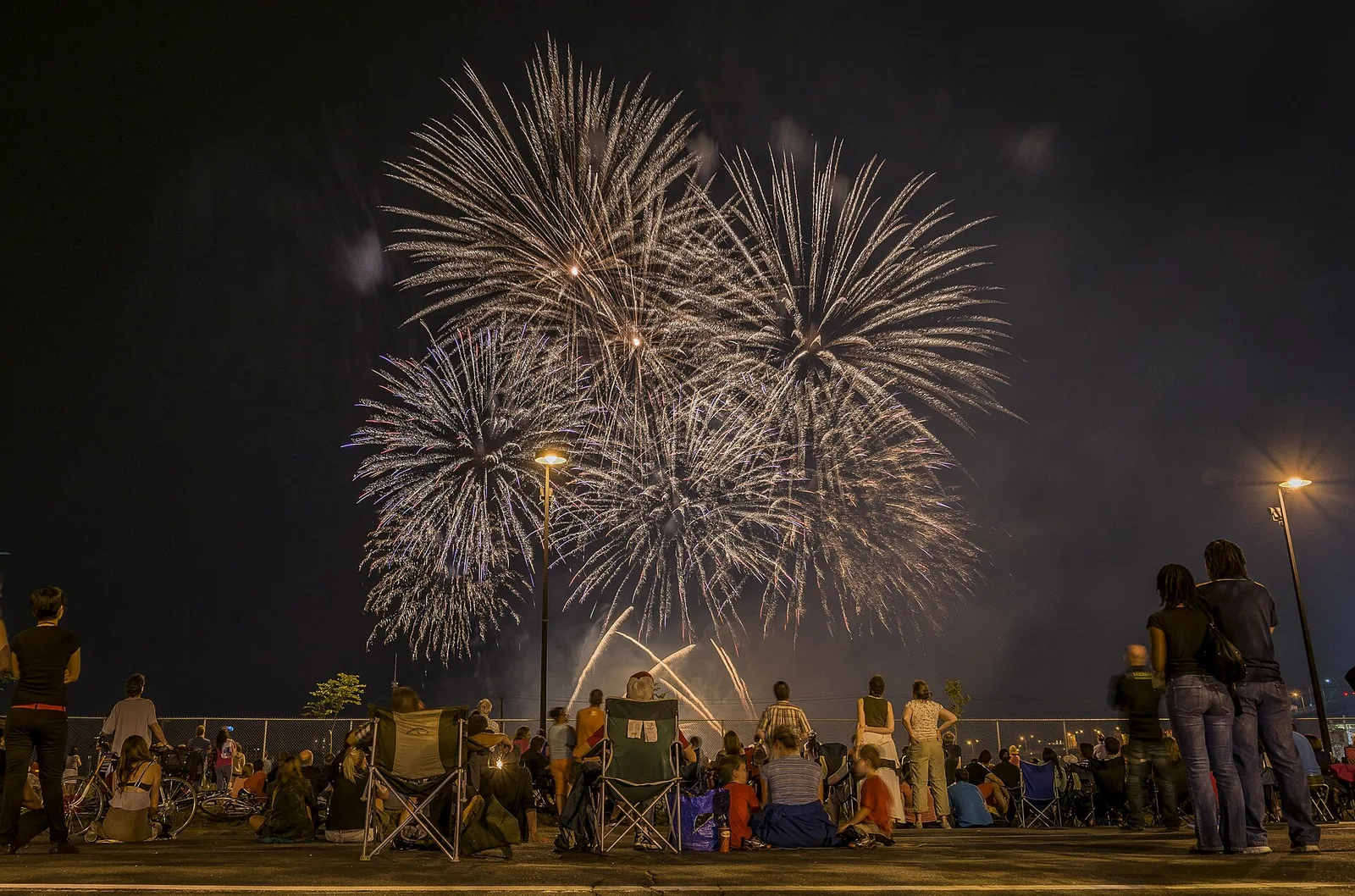 Spectators watching fireworks from the waterfront during L'International des Feux Loto-Québec, one of the summer Montreal events