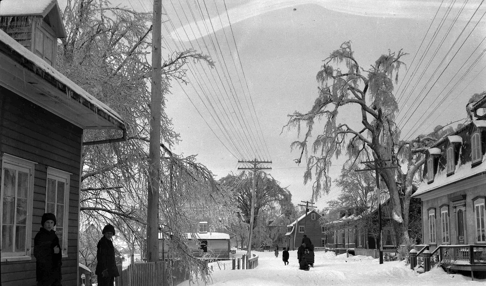Archival black-and-white photograph of a Montreal street with ice-coated trees and wires after an ice storm