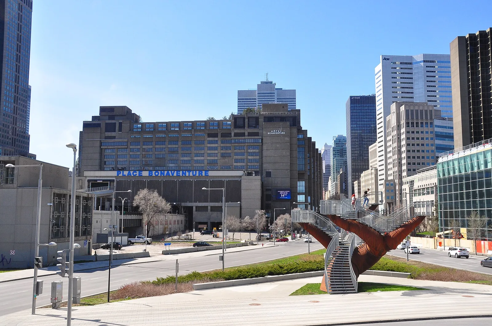 Downtown Montreal in spring, with bare trees, office towers and Place Bonaventure under a clear blue sky