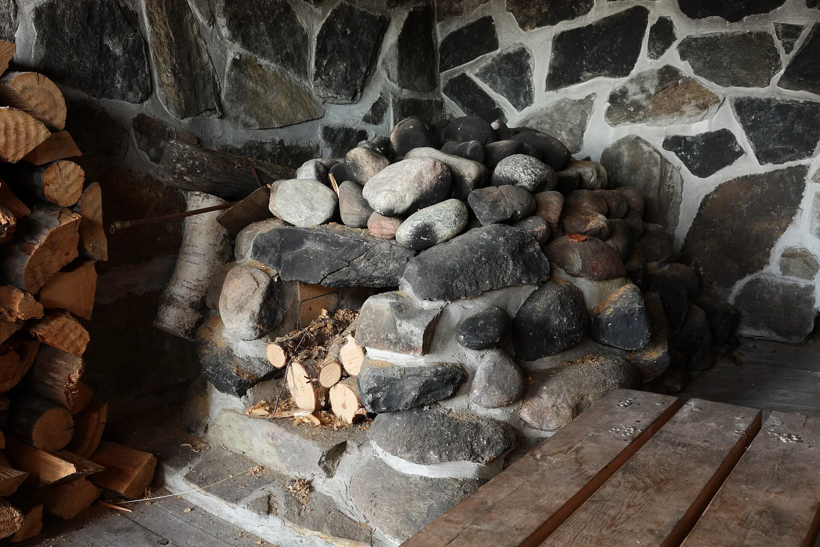 Stones heaped over a wood-fired stove in a traditional Finnish sauna, the heat stage of the Nordic thermal circuit